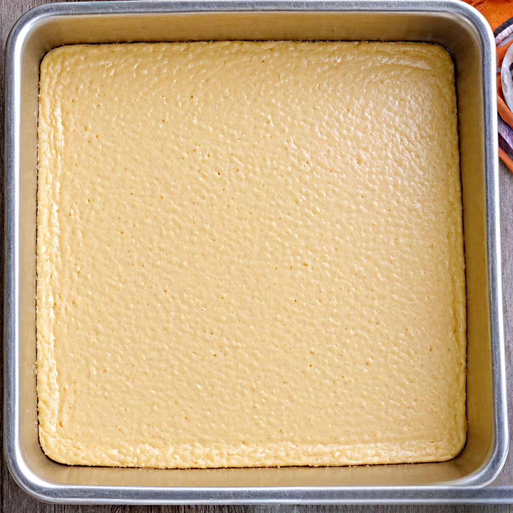 This image shows the pumpkin cake batter in square cake pan.