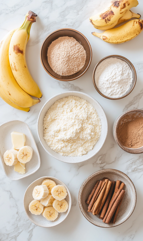 banana Cake recipe ingredients- 3 ripe bananas (mashed with a fork), 3 cups all-purpose flour, 1 ½ tsp baking soda, ¼ tsp salt, 1 cup unsalted butter (melted), 1 cup granulated sugar, ½ cup brown sugar, 3 large eggs, ½ tsp ground cinnamon, 1 tsp vanilla ex