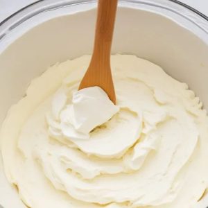 this-image-shows-mixing-of-some-cream-cheese-unsalted-butter-and-vanilla-extract-with-spatula